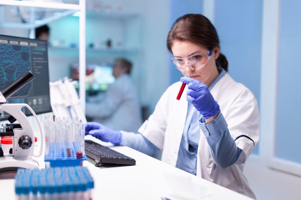 Biotechnolog-naukowczyni prowadzi badania z użyciem probówki w laboratorium. Nowoczesne laboratorium do badań naukowych z profesjonalnym sprzętem