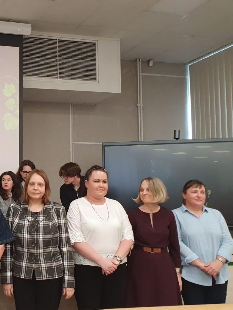 Grupa 4 elegancko ubranych naukowczyń stoi w auli przed ogłoszeniem wyników plebiscytu
